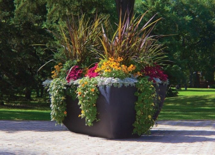 Large commercial self-watering planters with colorful flowers used for park and streetscape landscaping.